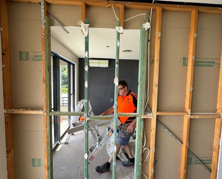 Carpenter working inside a newly framed internal wall opening