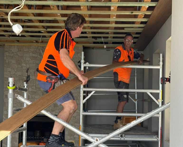 SEQ carpenters lifting a curved timber bulkhead into place
