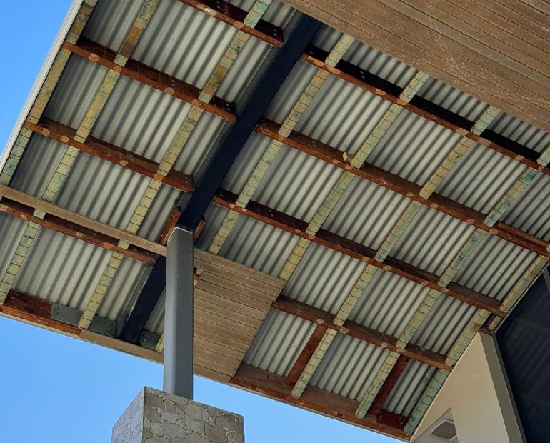 Underside of a patio ceiling mid-replacement showing timber battens