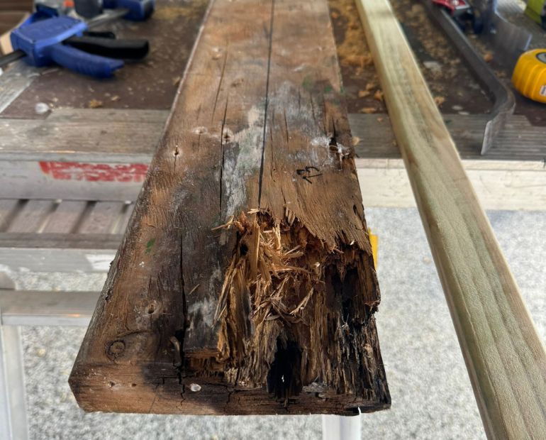 Damaged beam beside its replacement timber